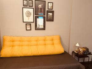 a yellow couch in a room with pictures on the wall at Val Rosandra 