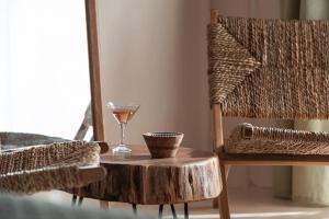a wooden table with a glass of wine and a chair at Kynthia Hotel - Adults Only in Kalogria