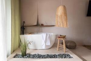 a bath tub in a bathroom with a potted plant at Kynthia Hotel - Adults Only in Kalogria