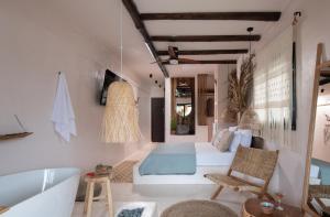 a bedroom with a tub and a bed and a bath room at Kynthia Hotel - Adults Only in Kalogria