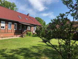 a brick house with a red roof and a yard at Landliebe Aulosen in Aulosen