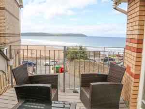 a balcony with chairs and a view of the beach at Beach Lodge in Woolacombe