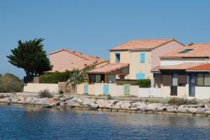 a row of houses next to a body of water w obiekcie Maison à Coudalère, entre étang et mer ! w mieście Le Barcarès