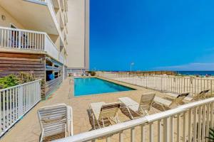a balcony with chairs and a swimming pool and the ocean at Caribbean Unit 602 in Gulf Shores