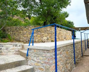 una rampa di scale con ringhiera blu su un muro di pietra di To Provetzino a Viarádhika