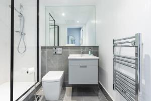 een witte badkamer met een toilet en een wastafel bij Woodward Square One by Dublin At Home in Dublin