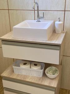 a bathroom with a sink and two rolls of toilet paper at Hospedaria Spring in Alfenas
