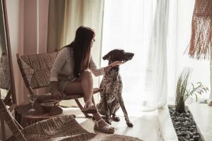 a woman sitting in a chair with a dog at Kynthia Hotel - Adults Only in Kalogria