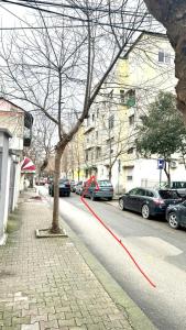 uma rua com carros estacionados na berma da estrada em Host Apartament Elio em Tirana