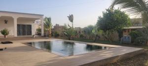 a swimming pool in front of a house at Keur Aïda in Malikounda Sas