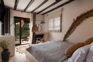 a bedroom with a large bed and a patio at Kynthia Hotel - Adults Only in Kalogria