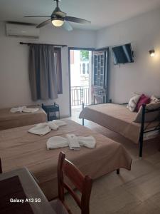 a hotel room with two beds with towels on them at Αrgo Studios in Pythagoreio