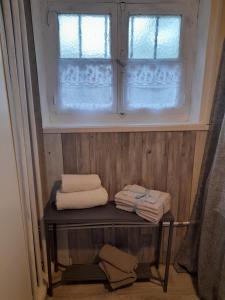 a bathroom with towels on a shelf in front of a window at Smith Cosy in Châteaumeillant