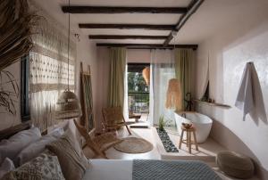 a bedroom with a bed and a tub in a room at Kynthia Hotel - Adults Only in Kalogria