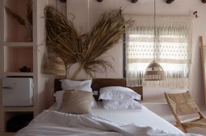a bedroom with a bed with white sheets and pillows at Kynthia Hotel - Adults Only in Kalogria