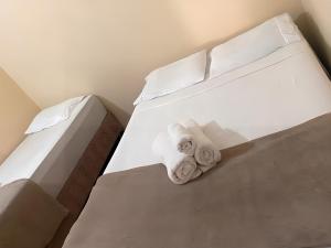 a bedroom with two towels on a bed at Hospedaria Spring in Alfenas