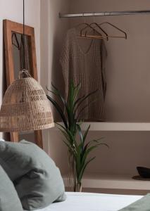 a bedroom with a bed and a lamp and a plant at Kynthia Hotel - Adults Only in Kalogria
