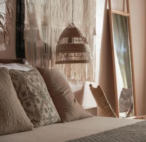 a bedroom with a bed with a chandelier and a window at Kynthia Hotel - Adults Only in Kalogria