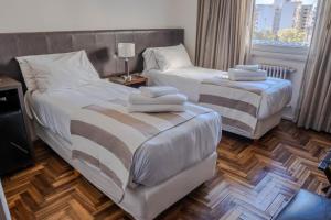2 camas en una habitación de hotel con toallas en Gran Hotel Panamericano en Mar del Plata