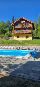 a house with a blue pool in front of it at Barvy Karpat in Slavske