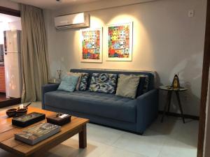 a living room with a blue couch and a table at CPR - Apartamentos a 200m da praia com Piscina in Marau