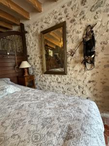 1 dormitorio con cama y espejo en la pared en Chambres d'Hôtes de la Vallée Javot en Féricy