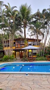 a resort with a swimming pool and palm trees at Pousada Serra da Bocaina Paraty in Paraty