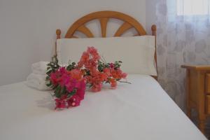 um ramo de flores sentado em cima de uma cama em Casa Iantmar 2 em El Altet
