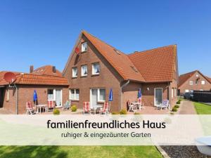 a house with a yard with tables and chairs at Robbe 2 in Bensersiel