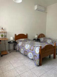 a bedroom with two beds and a table with lamps at Su Tostobiu in San Nicolò dʼArcidano