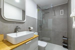 un bagno con un lavandino bianco e una doccia di Pursuit of Ocean a Las Palmas de Gran Canaria Altre 14 foto