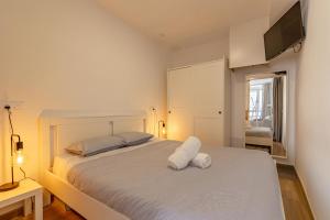 una camera da letto con un letto bianco e una TV a parete di Pursuit of Ocean a Las Palmas de Gran Canaria