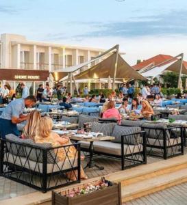 a group of people sitting at tables in a restaurant at Sea Breeze White Villa in Baku