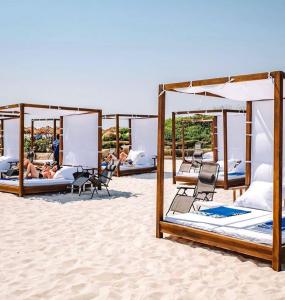 a group of beds on a sandy beach at Sea Breeze White Villa in Baku