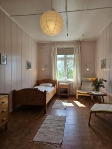 a bedroom with a bed and a large window at Fokhol Gård Gjestehus in Stange