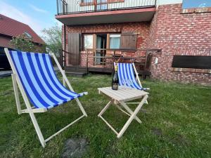 deux chaises et une table avec une bouteille de vin dans l'établissement Apartament Nostalgia, à Gąski