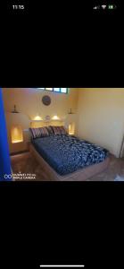 a bedroom with a bed with blue sheets and lights at Maison Ayachi in El Aadamna