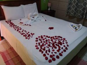 a bed with a heart made out of red pedals at Chalé da Pousada Avalon Célia in Alto Paraíso de Goiás