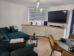 a living room with a green couch and a table at Apartament Forest in Radków
