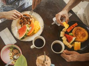 una mesa cubierta con platos de comida y bebida para el desayuno en La Posada - Hostel, en Santa Teresa Beach