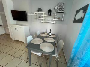 d'une salle à manger avec une table, des chaises et une télévision. dans l'établissement Apartament Nostalgia, à Gąski 9 autres photos