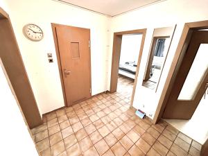 a hallway with a door and a clock on the wall at Kulturmensch Oberhausen mit Balkon in Oberhausen