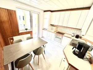 a kitchen with a table and chairs in a room at Kulturmensch Oberhausen mit Balkon in Oberhausen