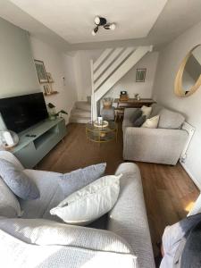 ein Wohnzimmer mit einem Sofa und einem TV in der Unterkunft Cosy home close to M6 motorway in Pemberton