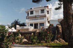 una casa blanca en una colina con un árbol en Yıldız Villa, en Alanya