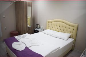 1 dormitorio con 1 cama con 2 almohadas blancas en Kümbet Hotel, en Estambul