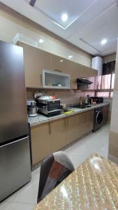 メクネスにあるBel appartement dans une résidence calmeのキッチン(ステンレス製の冷蔵庫、テーブル付)