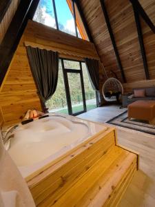 Habitación con bañera grande y ventana grande. en ELAT Bungalow, en Pazar