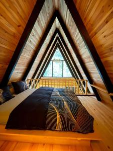Cama en un loft con ventana grande en ELAT Bungalow, en Pazar