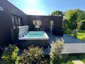 bañera de hidromasaje en la cubierta de una casa en Villa Louméa - Le Loft avec jacuzzi en Friesenheim